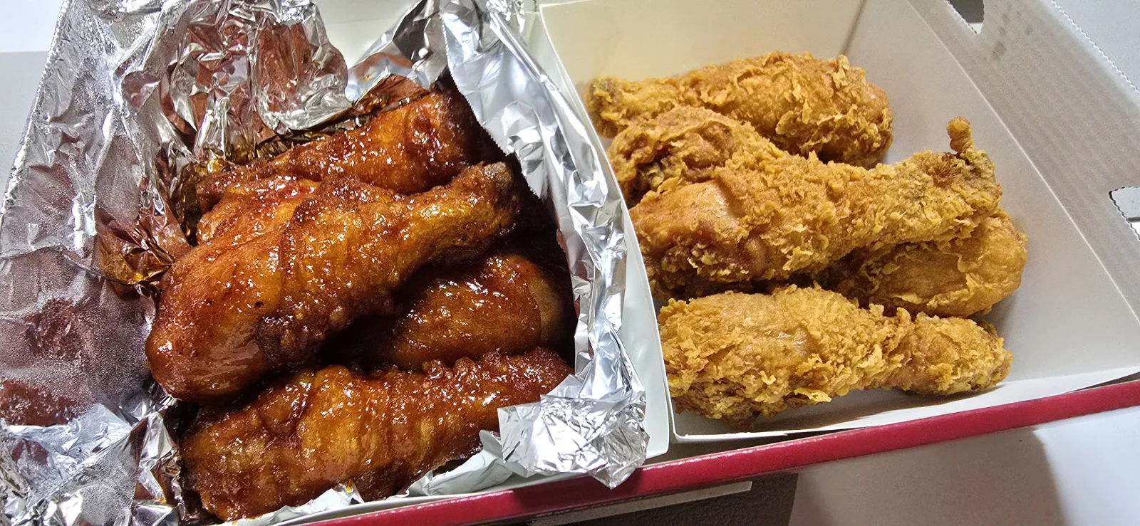 A half-and-half chicken box with glazed seasoned chicken on one side and plain fried chicken on the other. Photo: Ruliweb