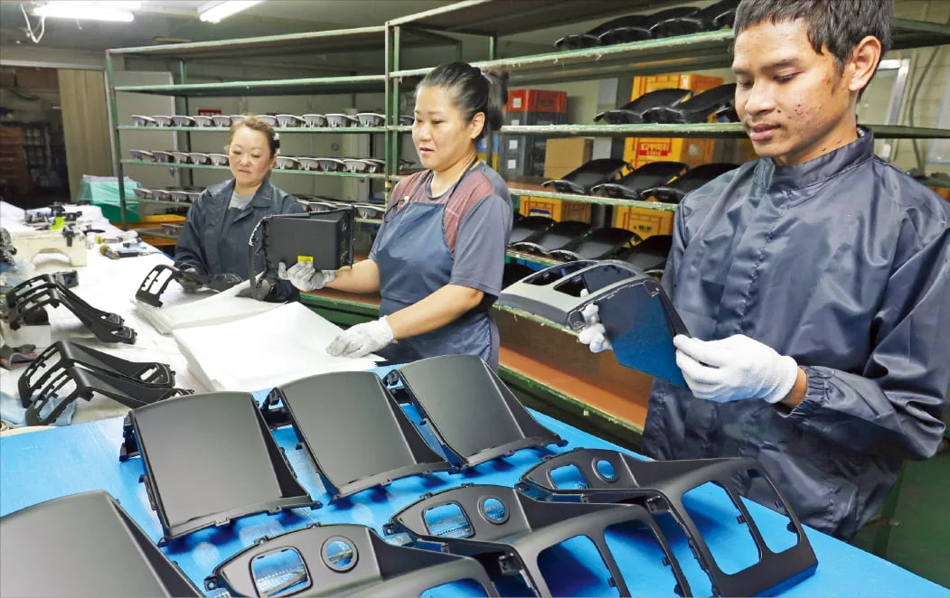 Foreign and Korean workers handling parts on a factory line. Source: Naver News
