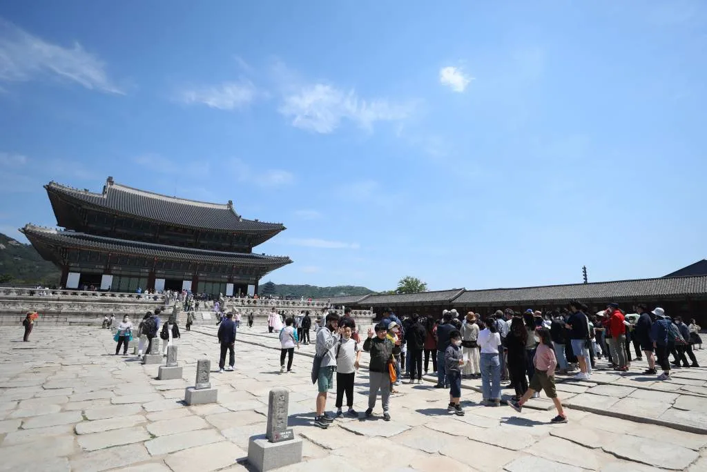 Visitors gathered in the main courtyard in front of Geunjeongjeon Hall at Gyeongbokgung Palace in Seoul.