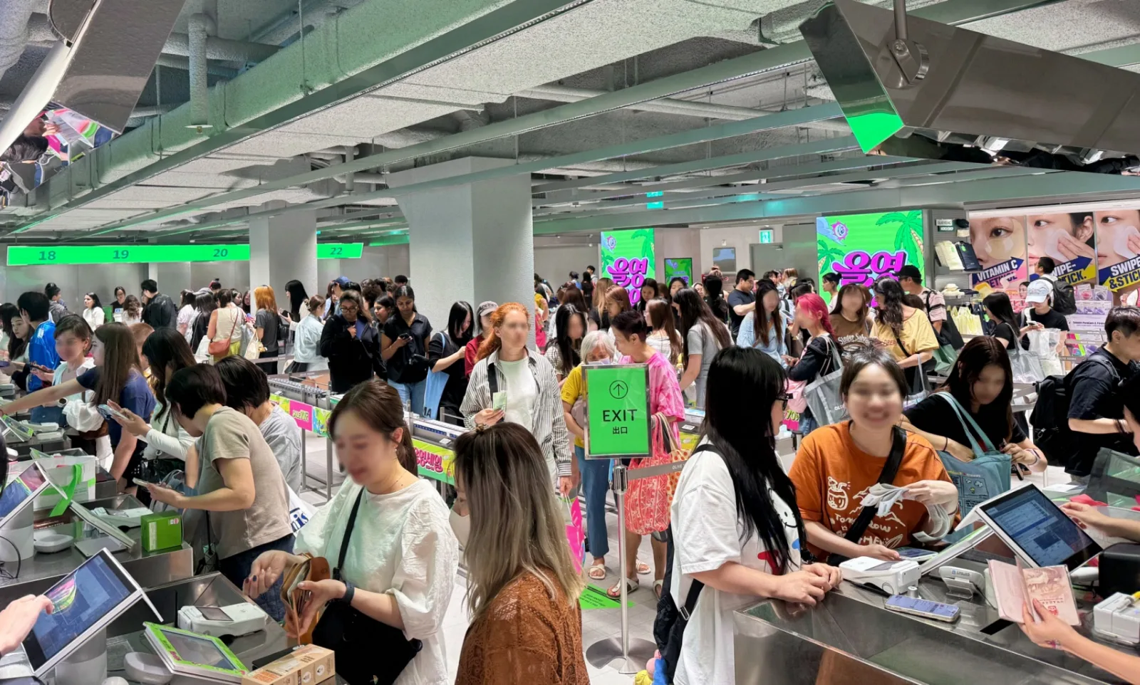 Shoppers queue at the checkout counters of an Olive Young store during a sale, with a passport visible at the right counter. Photo: Fashionbiz