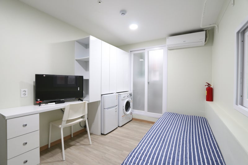 A private room inside a Korean goshiwon, with a desk, TV, small fridge and washing machine. Photo: Naver Blog (minioneroom)