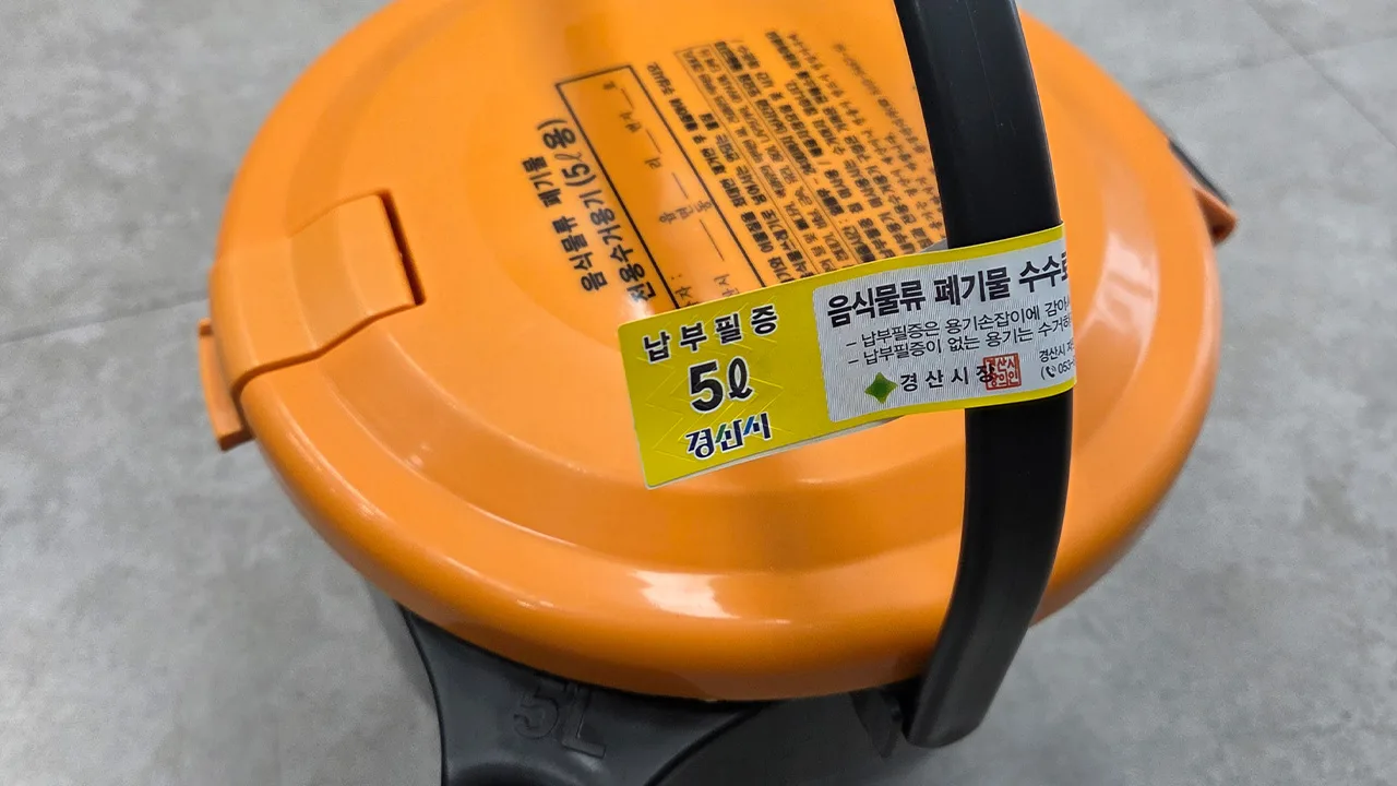 A dedicated food waste container with a payment sticker attached to its handle. Source: Daegu MBC