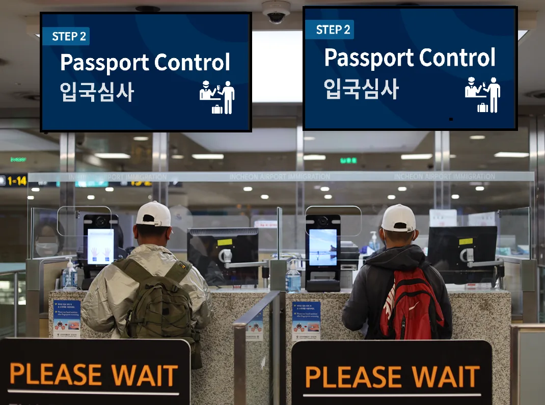 Two travelers wait at passport control booths at Incheon Airport immigration. Photo: Yonhap News
