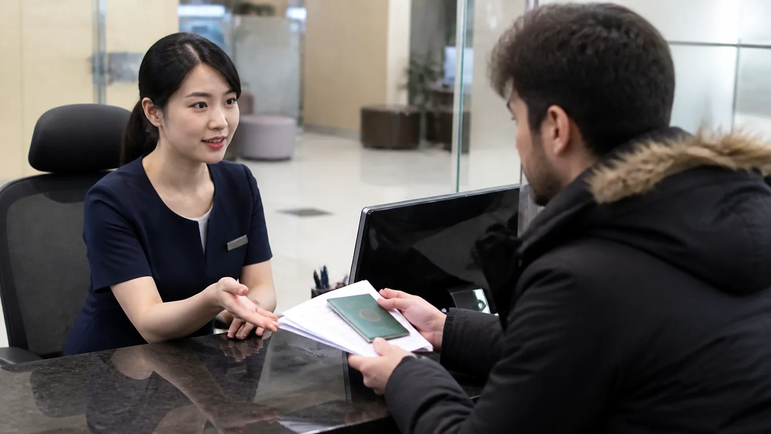 Foreign customer handing a passport to a bank teller at a Korean bank counter