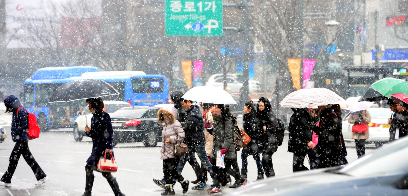 Snow falling on pedestrians crossing a street in Jongno, downtown Seoul. Photo: Kyunghyang Shinmun