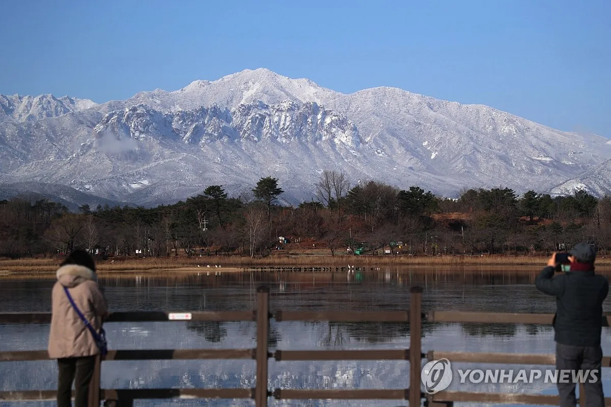 Snow-covered peaks of Seoraksan seen across a lake. Photo: Yonhap News