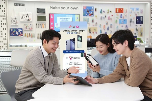 A staff member helping customers with a new phone at a Korean carrier store. Photo: Dong-A Ilbo